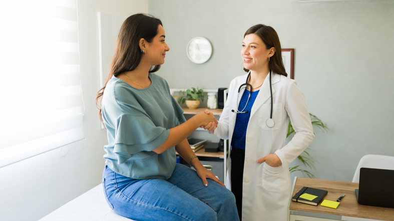 Clinician shaking hands with a patient at the start of an exam
